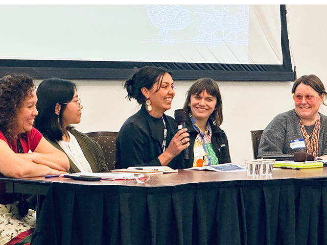 Five women seated at a panel table, one smiling while speaking into a microphone. UC Davis Department of Plant Sciences
