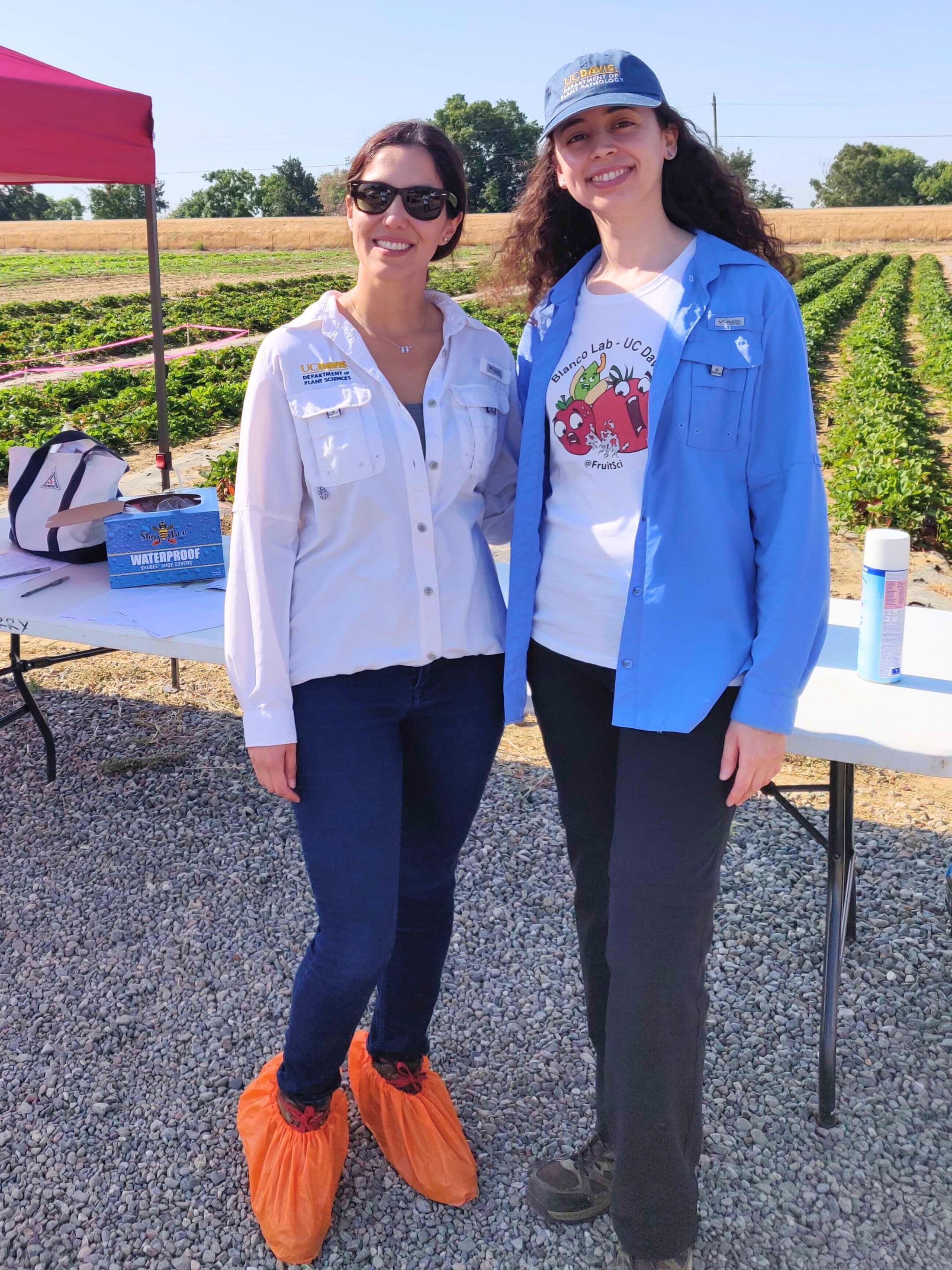 Two women smile in field 