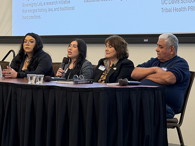 Four panelists seated at long table with microphones and projection screen behind them. UC Davis Department of Plant Sciences