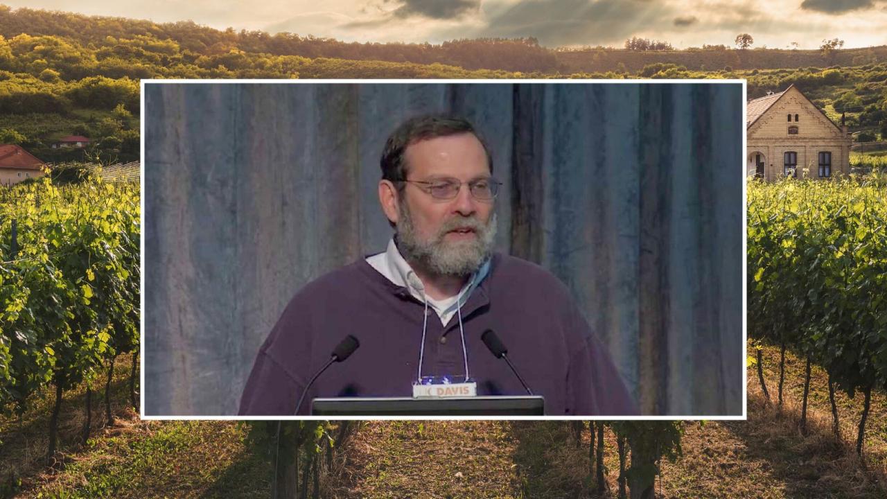 Bloom standing at podium. Field edited into background.