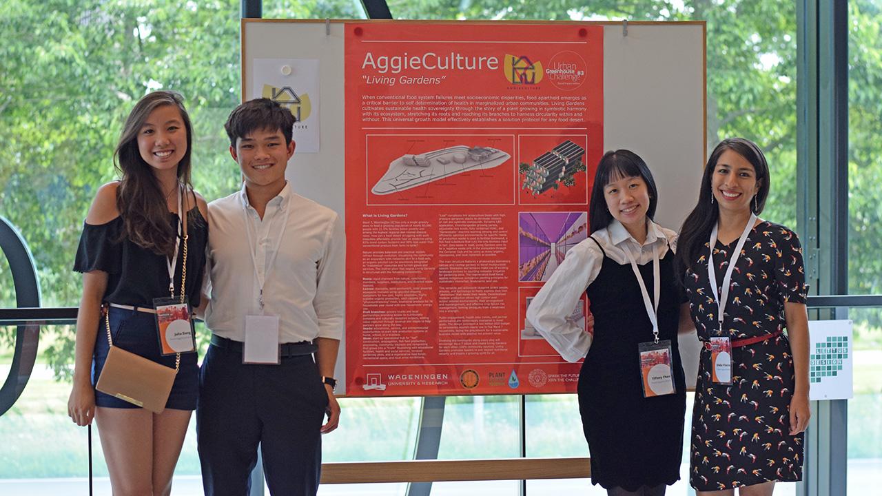 Four young people standing on either side of a scientific presentation poster