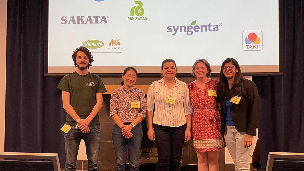 Five students in front of a screen with company names projected