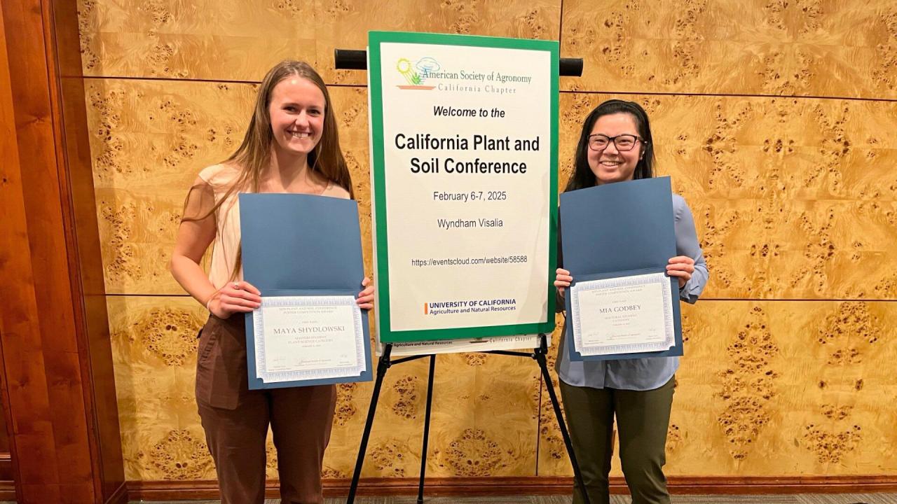 Two women stand proud with their certificates
