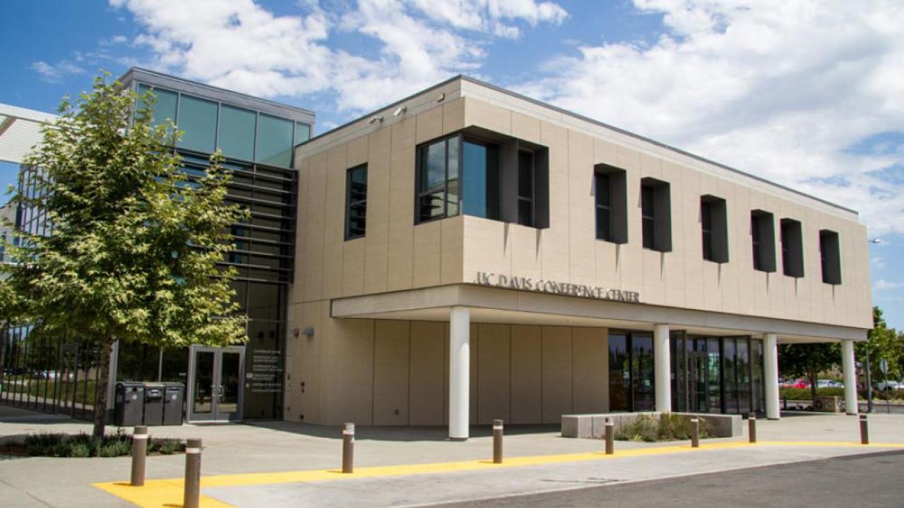 A large two story building with columns and trees around it