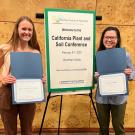 Two women stand proud with their certificates 